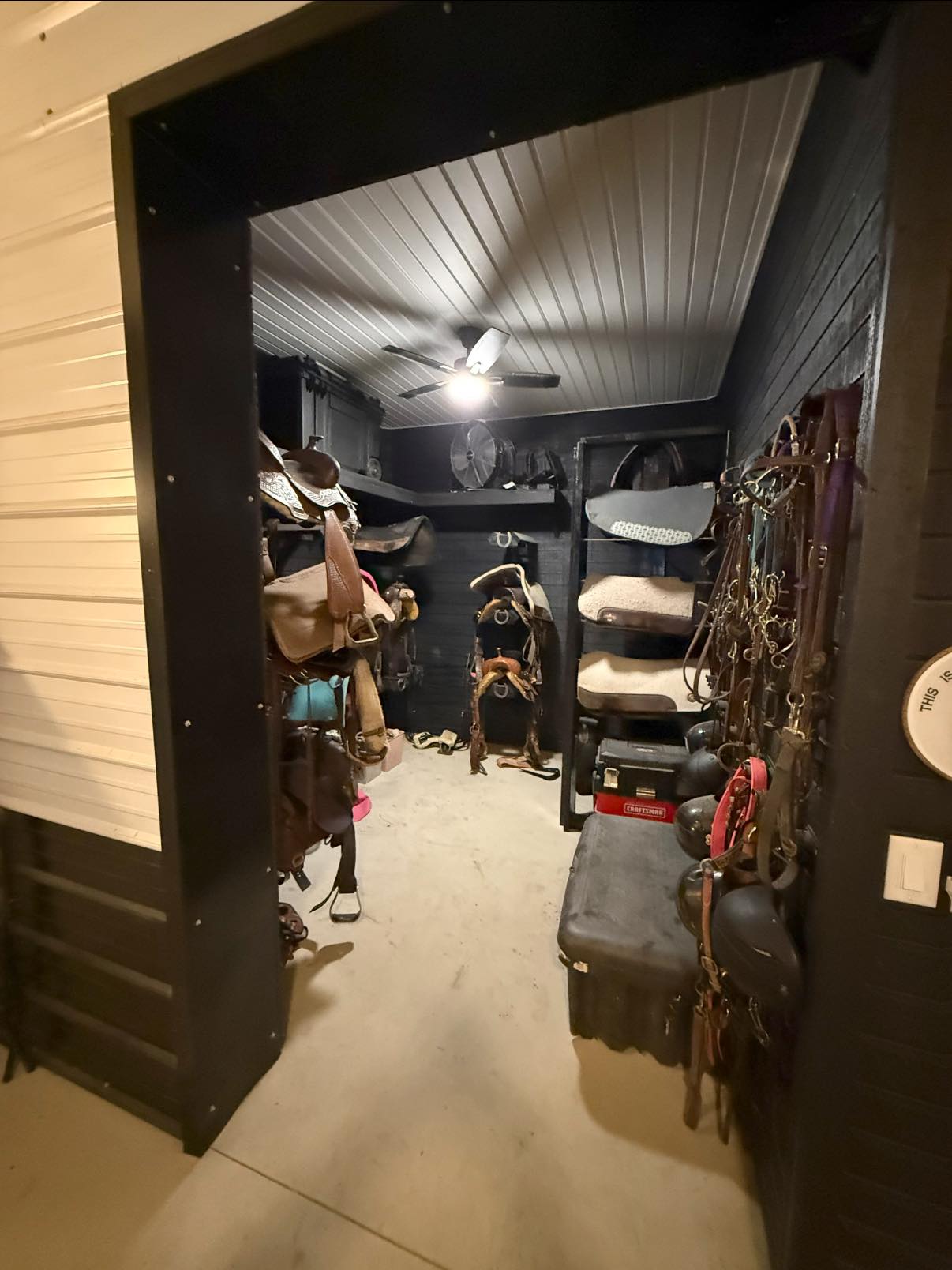 Organized tack storage area with saddles and riding equipment at Rodeo Stables