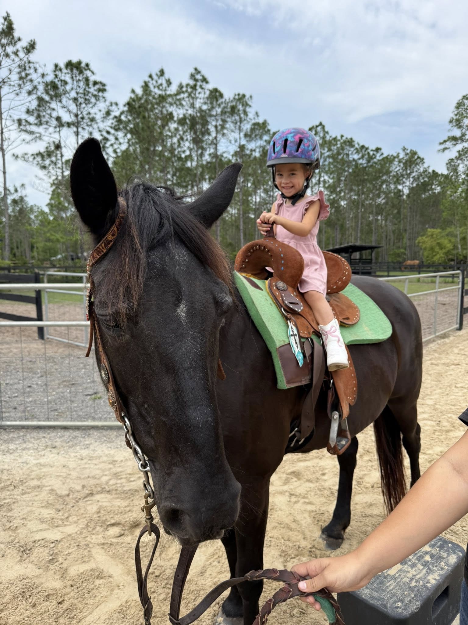 Young girl enjoying a guided horseback ride with instructors at Rodeo Stables in Ormond Beach, Florida.