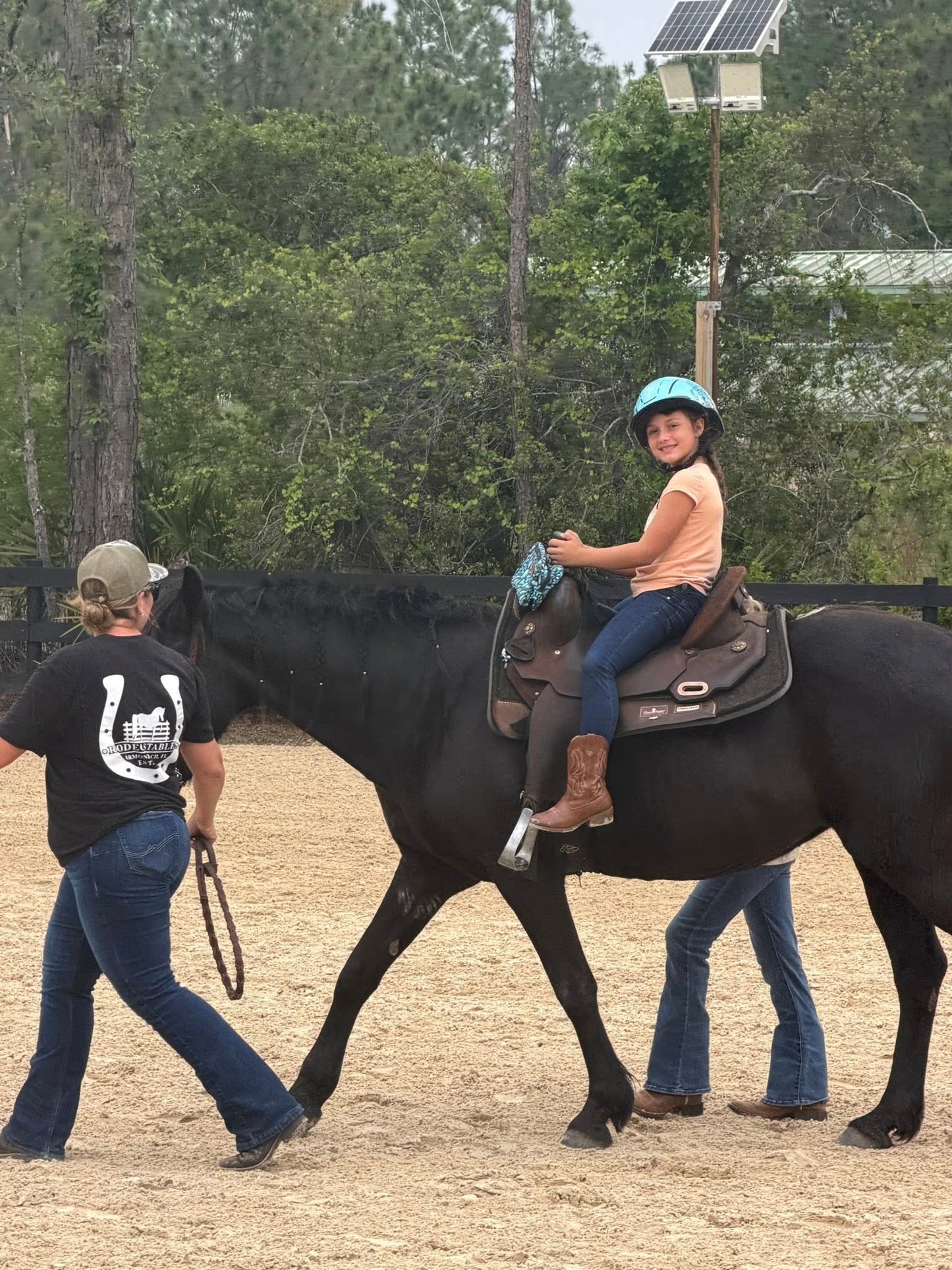 Young girl enjoying a guided horseback ride with instructors at Rodeo Stables in Ormond Beach, Florida.