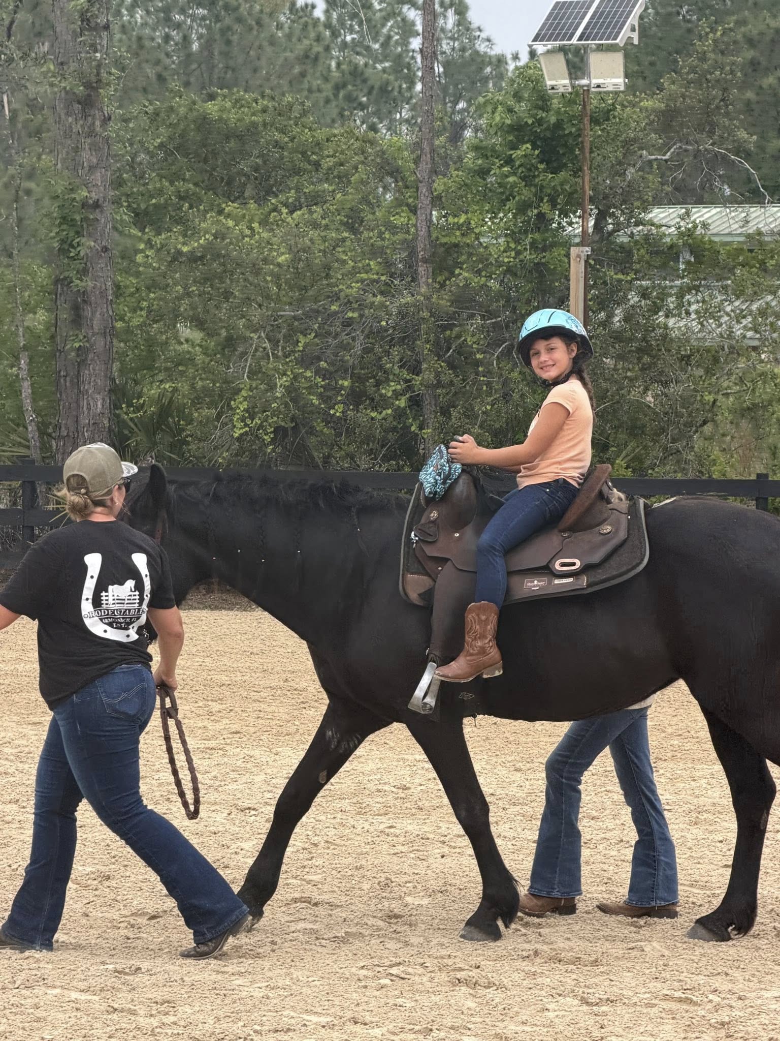 Young girl enjoying a guided horseback ride with instructors at Rodeo Stables in Ormond Beach, Florida.