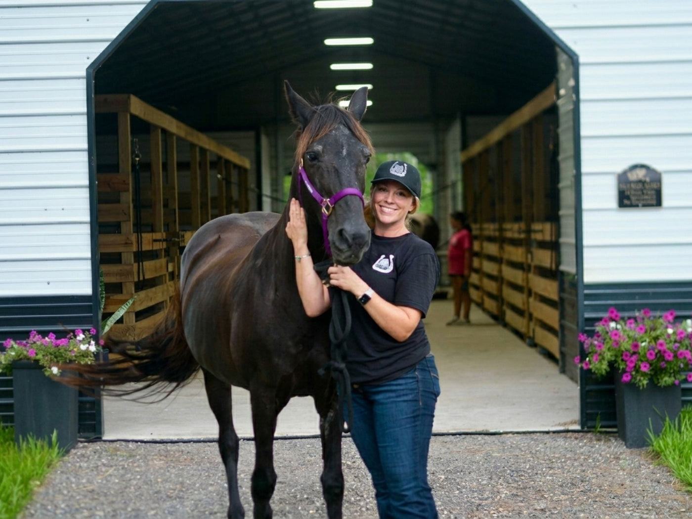 Woman with horse at barn entrance at Rodeo Stables