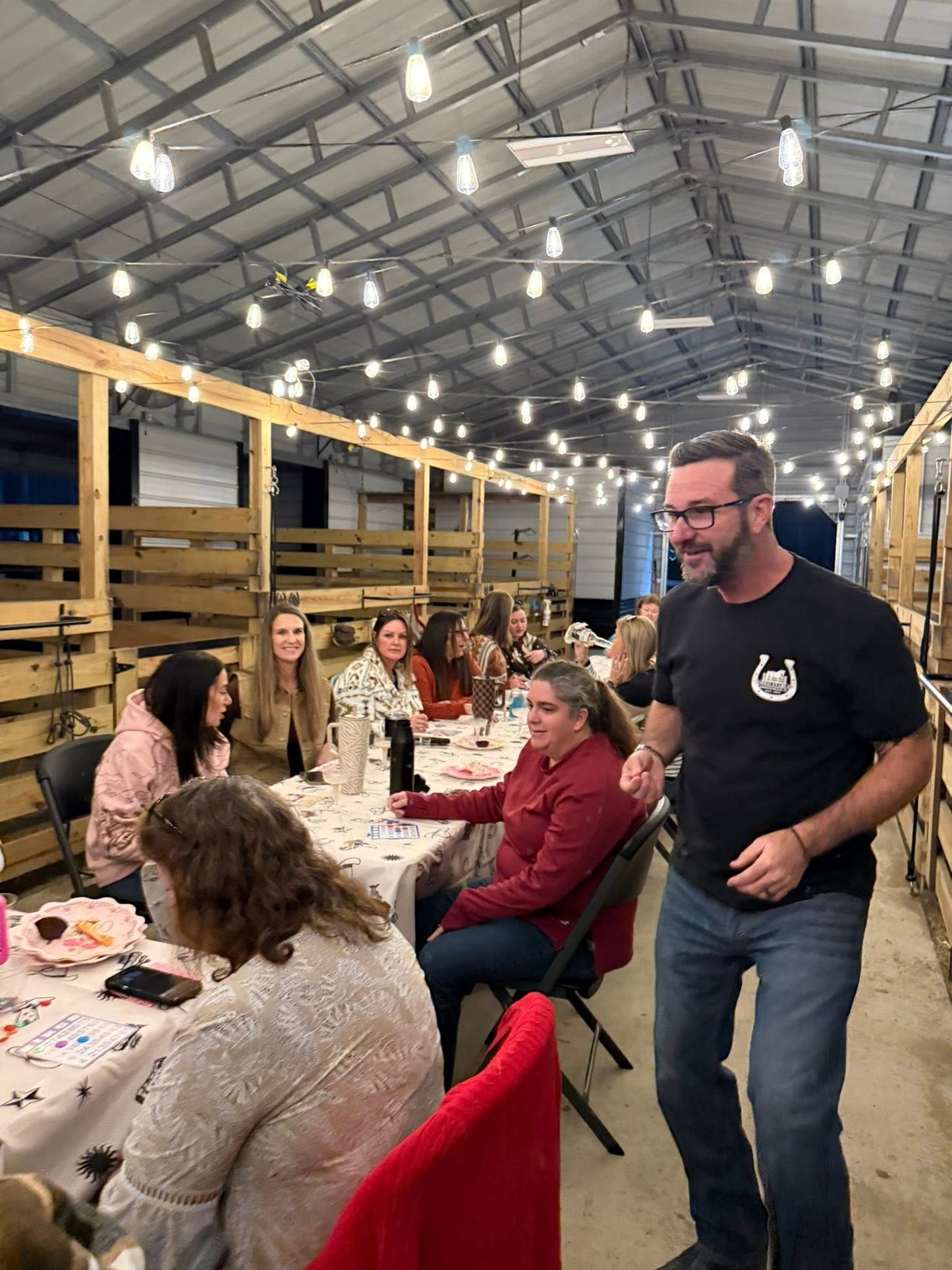 Guests gathered inside the Rodeo Stables barn during a private evening event in Ormond Beach, Florida.