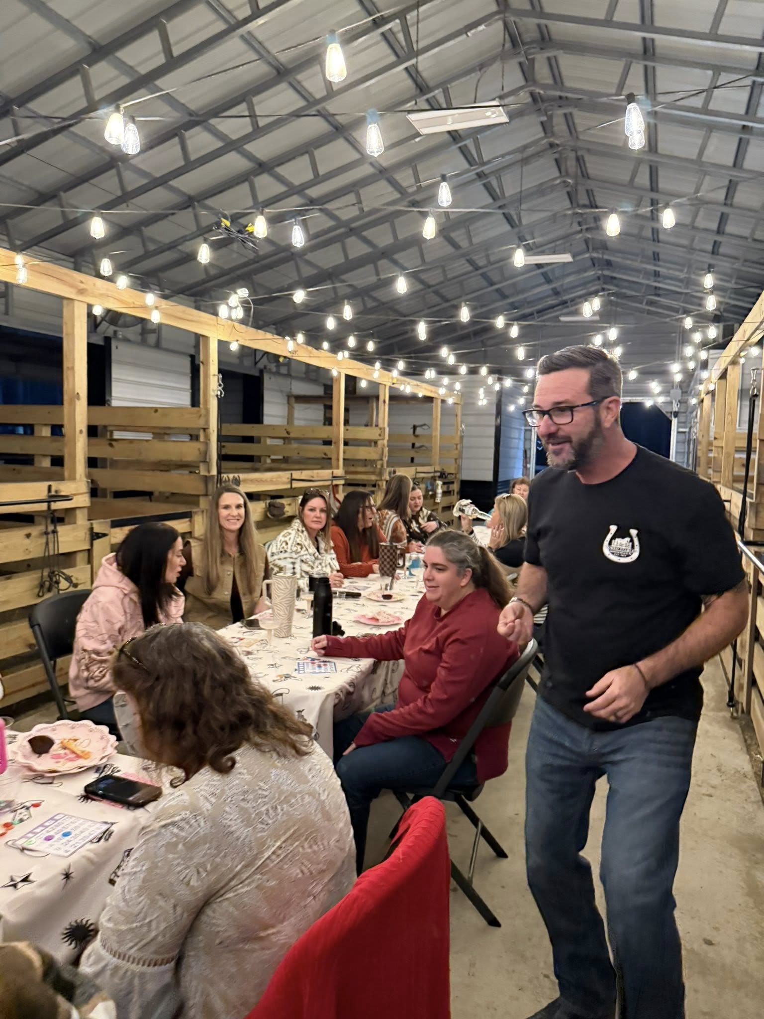 Guests gathered inside the Rodeo Stables barn during a private evening event in Ormond Beach, Florida.