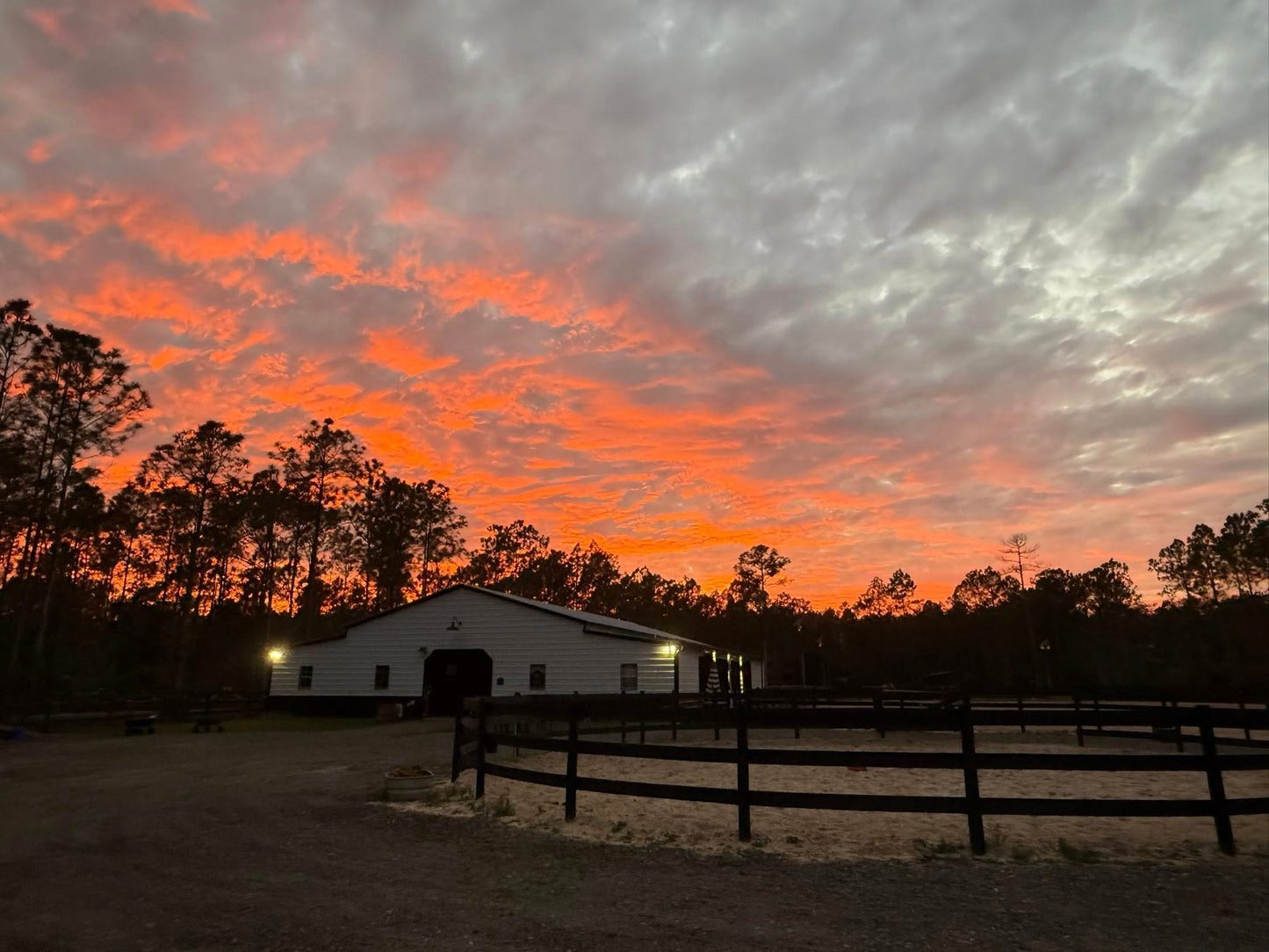 Sunset view over Rodeo Stables in Ormond Beach, Florida with horse fencing and glowing evening sky.